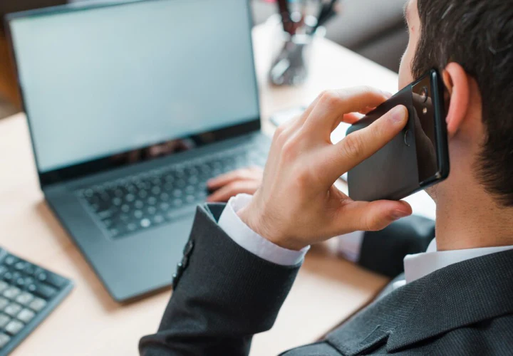 Person on phone with laptop